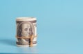 A roll of US dollar bills is tied with a brown string against a blue background Royalty Free Stock Photo
