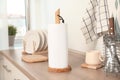 Roll of white paper towels and other kitchen stuff on wooden countertop indoors Royalty Free Stock Photo