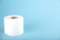 A roll of white toilet paper on a colored background. Space for text