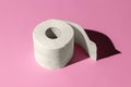 Roll of a white toilet paper isolated on a pink background close-up. hard shadows from the sun at noon Royalty Free Stock Photo