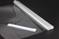 roll of white transparent film for baking with zippers on a black background, top view. Royalty Free Stock Photo