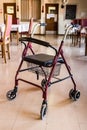 Rollator walker with a seat and a basket in an empty hall