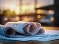 Rolled architectural blueprints resting on a table with soft evening light and blurred background creating a warm inspiring Royalty Free Stock Photo