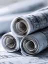 Rolled architectural plans stacked on detailed blueprints showcasing construction designs and engineering layouts for building Royalty Free Stock Photo