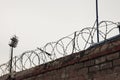 Rolled barbed wire against the cloudy sky