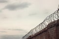 Rolled barbed wire against the cloudy sky