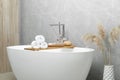 Rolled bath towels and personal care products on tub tray in bathroom Royalty Free Stock Photo