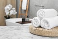 Rolled bath towels on white marble table in bathroom, space for text Royalty Free Stock Photo