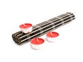 Rolled black bamboo mat and three red candles