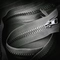 Rolled black zipper closeup, dark background, textile accessories. Concept of shopping, manufacturing