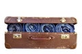 Rolled blue jeans pants in old suitcase isolated