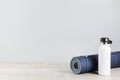 Rolled yoga mat and metal water bottle Royalty Free Stock Photo