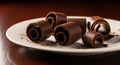Rolled chocolate curls arranged on a white plate against a dark background. The texture is smooth Royalty Free Stock Photo