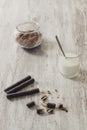 Rolled chocolate wafers, cocoa powder and a glass of milk on a rustic wooden background