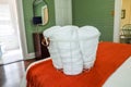 rolled clean towels in a wire basket sitting on a bed in a guest bedroom Royalty Free Stock Photo