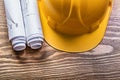 Rolled construction drawings hard hat on wooden board maintenanc Royalty Free Stock Photo