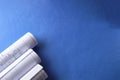 Rolled engineering drawings at blue background with copy space Royalty Free Stock Photo