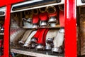 Rolled fire hoses, arranged in rows, in the glove compartment of the fire truck.