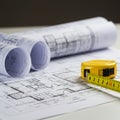 Rolled and flat architectural blueprints with technical drawings are visible on a white Royalty Free Stock Photo