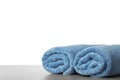 Rolled fresh clean towels for bathroom on table against background. Space for text Royalty Free Stock Photo