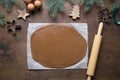 Rolled gingerbread dough and forms for christmas cookies on brown wooden background. Process of making handmade cookies. Christmas