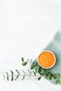 Rolled towel, orange bath salt and green eucalyptus branch on white background. Hygiene, wellness well-being, body care concept. Royalty Free Stock Photo
