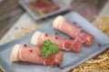 Rolled ham slices with herbs on a table