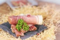 Rolled ham slices with herbs on a table