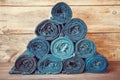 Rolled jeans stack on wooden background.