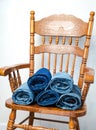 Rolled jeans of various shades lie on a vintage wooden chair Royalty Free Stock Photo