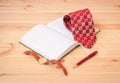 Rolled necktie, diary, watch and pen on wooden table. Selective focus Royalty Free Stock Photo