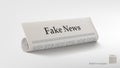 Rolled Newspaper With Big Title Fake News