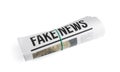 Rolled newspaper with headline FAKE NEWS on white background Royalty Free Stock Photo