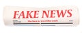 Rolled newspaper with headline FAKE NEWS on white background Royalty Free Stock Photo