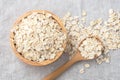 Rolled oat, raw oatmeal with spoon in wooden bowl