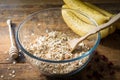 Rolled oats, bananas, nuts and spices in bowl on wooden table