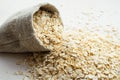 Rolled oats in burlap bag on wood table Royalty Free Stock Photo