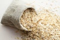 Rolled oats in burlap bag on wood table Royalty Free Stock Photo