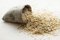 Rolled oats in burlap bag on wood table Royalty Free Stock Photo