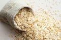 Rolled oats in burlap bag on wood table Royalty Free Stock Photo