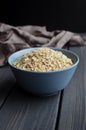 Rolled oats in ceramic bowl on dark wooden table with texture Royalty Free Stock Photo