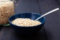 Rolled oats, healthy breakfast cereal oat flakes in bowl on dark wooden table with texture Royalty Free Stock Photo