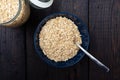 Rolled oats, healthy breakfast cereal oat flakes in bowl on dark wooden table with texture Royalty Free Stock Photo
