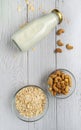 Rolled oats or oat flakes in bowl with oat milk and Cashew nuts on white wood background. Top view, Vertical. Healthy lifestyle, Royalty Free Stock Photo