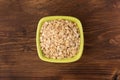 Rolled oats or oat flakes in bowl on wooden background Royalty Free Stock Photo