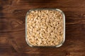 Rolled oats or oat flakes in bowl on wooden background. Royalty Free Stock Photo