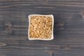 Rolled oats or oat flakes in bowl on wooden background Royalty Free Stock Photo