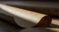 A rolled parchment lies on a flat surface, its edges softly curling. The material appear Royalty Free Stock Photo