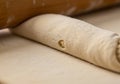 Rolled pastry dough with a smooth, light texture is close to a wooden rolling pin. The dough is Royalty Free Stock Photo