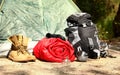 Rolled sleeping bag and other camping gear outdoors